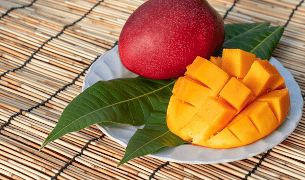 Which tropical fruit features bright orange, juicy flesh with a sweet aroma and is often hailed as the 