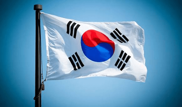 Which country's flag features a white background with a red and blue yin-yang symbol and four black trigrams in the corners?