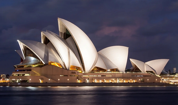 Designed by Danish architect Jørn Utzon and opened in 1973, which iconic performing arts center in Australia is instantly recognizable by its sail-like roof shells?