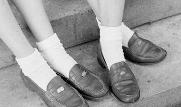 Teenagers often slipped a specific coin into the decorative slot of their leather shoes, giving the footwear its famous 