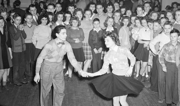 Why did students take off their saddle shoes and dance in their socks during 1950s gym dances?