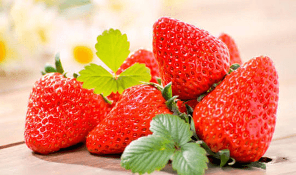 Unlike apples or peaches that grow on trees, which heart-shaped red fruit grows close to the ground on low garden runners?