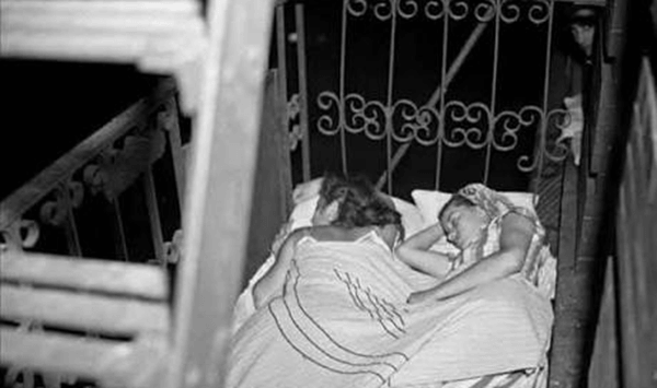 Before air conditioning, where did city residents sleep to stay cool?