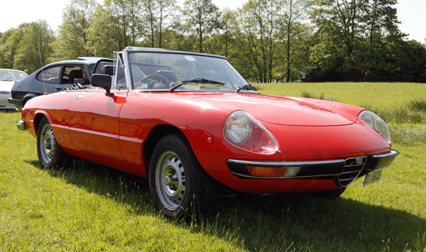 Which Italian roadster remained in production for nearly thirty years and was a close competitor to the Jaguar E-Type?