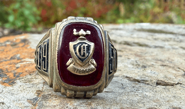 For those who didn't buy a heavy class ring, what smaller piece of personalized jewelry featuring their graduation year was worn on a necklace or letter jacket?