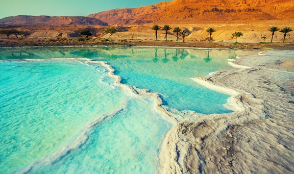 Located between Jordan and Israel, which body of water sits at the lowest land elevation on Earth-nearly 1,400 feet below sea level?