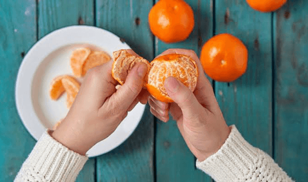 Which small, orange citrus fruit is popular during winter, easy to peel by hand, and loved for its sweet, seedless segments?