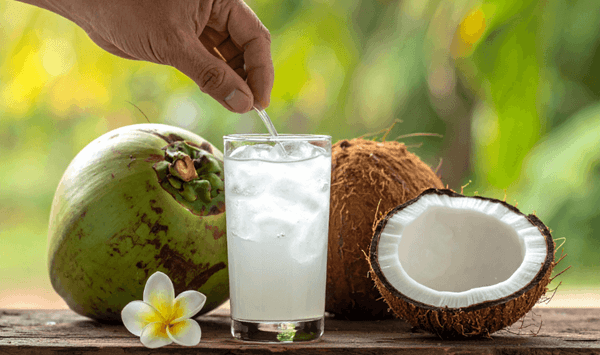 Which large tropical fruit has a hard, hairy brown shell and is filled with clear, refreshing water and rich white flesh inside?